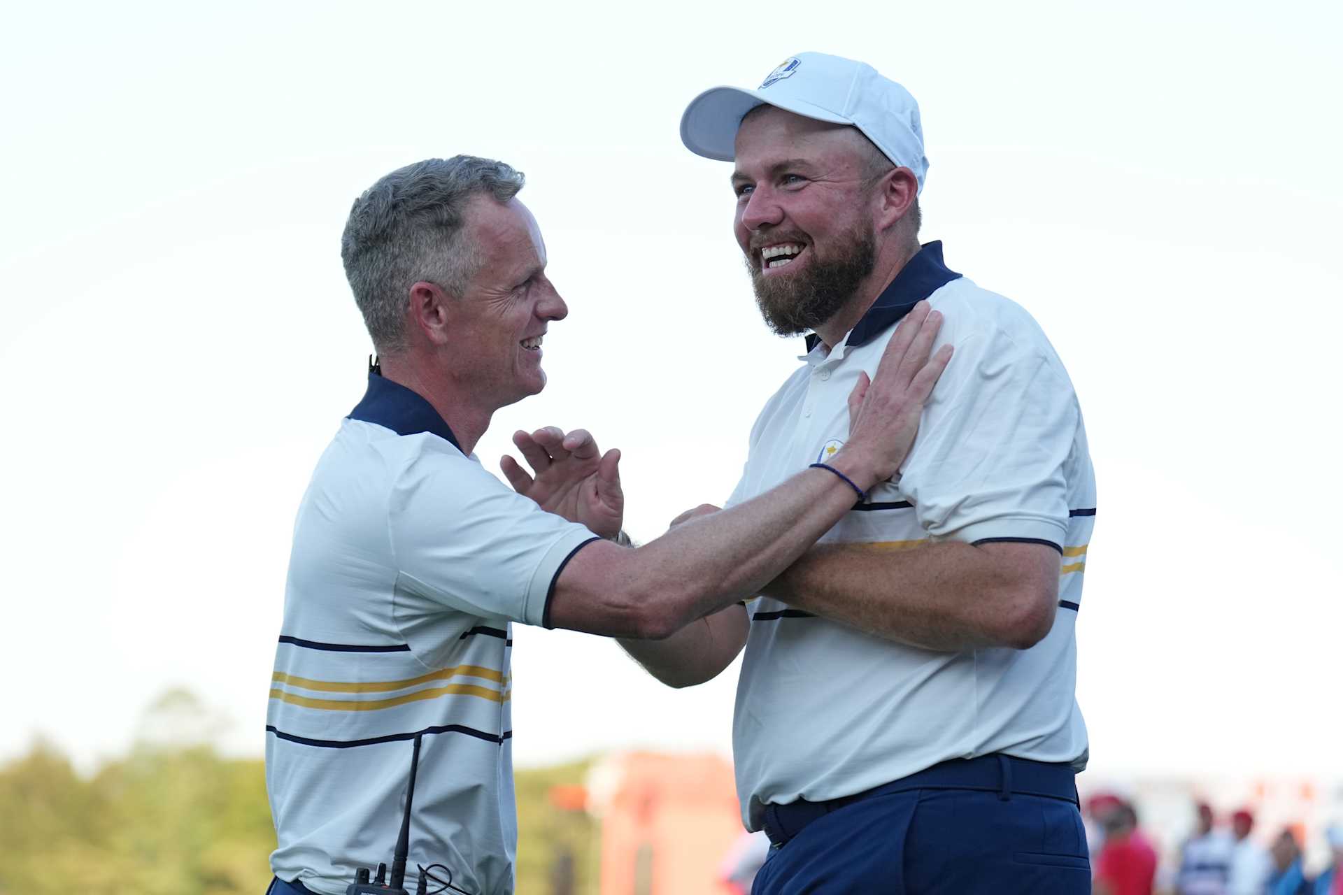 FARMINGDALE, NEW YORK - SEPTEMBER 28: (L-R) Captain Luke Donald of Team Europe and Shane Lowry of Team Europe hug after Lowry makes his putt to halve the hole and retain the Ryder Cup during the Sunday singles matches of the 2025 Ryder Cup at Black Course at Bethpage State Park Golf Course on September 28, 2025 in Farmingdale, New York. (Photo by Mike Stobe/Getty Images)