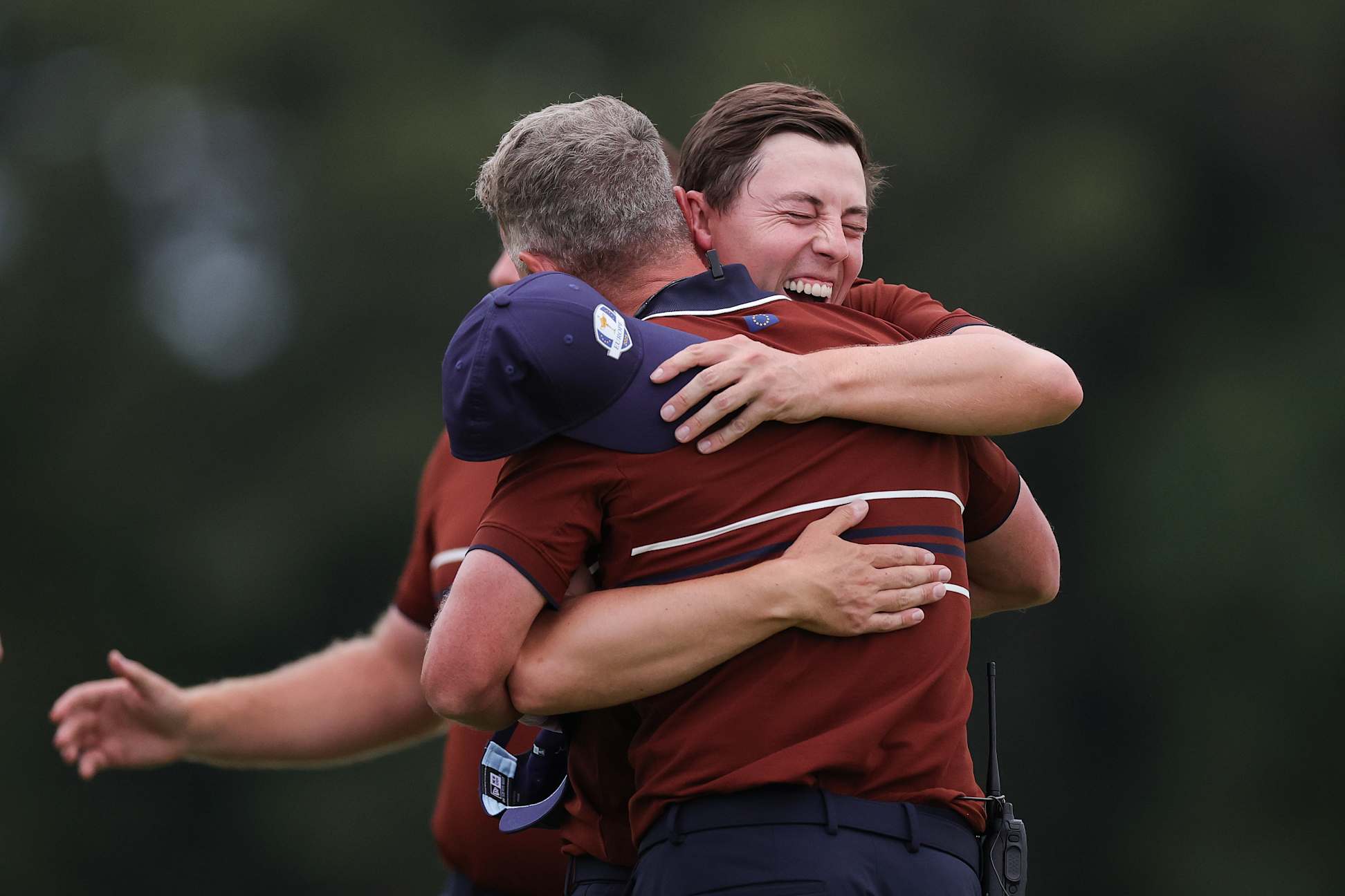 FARMINGDALE, NEW YORK - SEPTEMBER 27: Matt Fitzpatrick of Team Europe hugs team captain Luke Donald on the 18th hole green after Fitzpatrick and teammate Tyrrell Hatton defeated Sam Burns and Patrick Cantlay of Team United States, 1-up, during the Saturday afternoon four-balls matches of the 2025 Ryder Cup at Black Course at Bethpage State Park Golf Course on September 27, 2025 in Farmingdale, New York. (Photo by Andrew Redington/Getty Images)